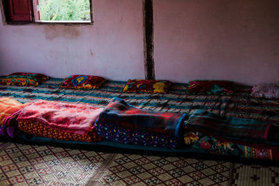 Multi colored sofa on bed against wall