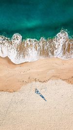 High angle view of surf on sea shore