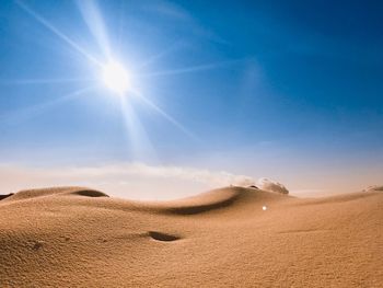 Scenic view of desert against sky on sunny day