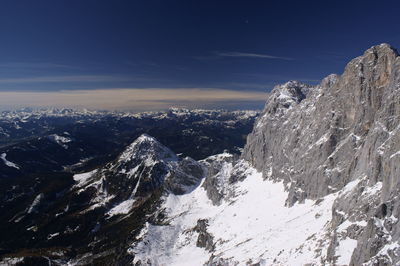 Scenic view of snowcapped mountains against blue sky