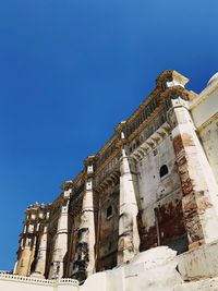 Low angle view of historic building against clear blue sky