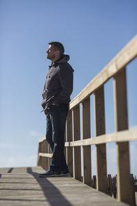 Low angle view of man looking away against sky