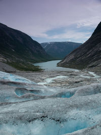 Scenic view of lake by mountains against sky