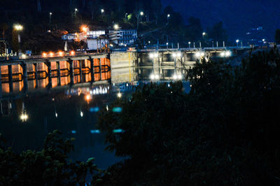 Illuminated city against sky at night