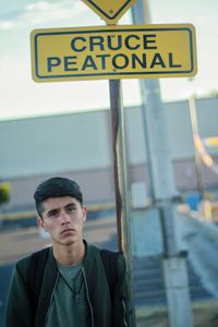 Portrait of man standing by information sign