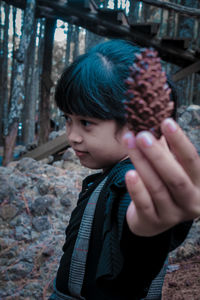 Close-up of girl holding pine cone