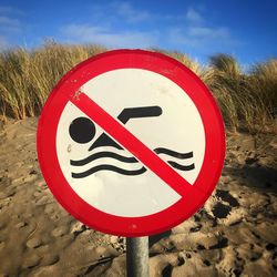 Close-up of road sign on beach