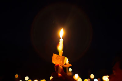 Close-up of lit candles in darkroom