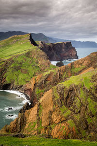 Scenic view of mountains and sea against cloudy sky