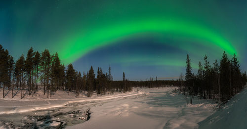 Snow covered landscape against sky at night