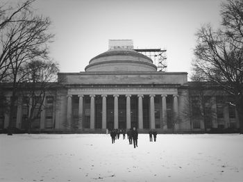 Building with bare trees in foreground