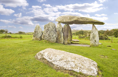 Stone structure on field against sky