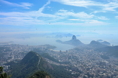 Aerial view of city and mountains against sky