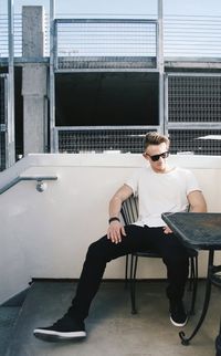 Full length of man sitting on chair at cafe