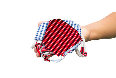 Close-up of hand holding umbrella against white background