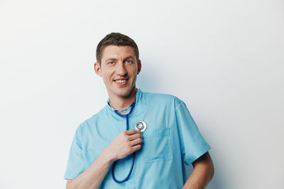 Portrait of young man standing against white background