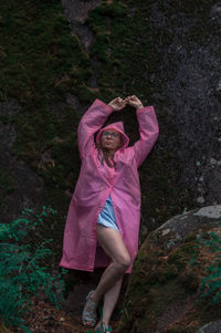 Portrait of young woman standing against plants
