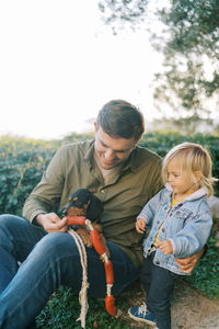 Side view of siblings sitting on field