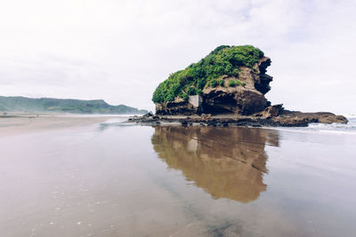 Rock formations by sea against sky