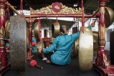 Rear view of man working in temple