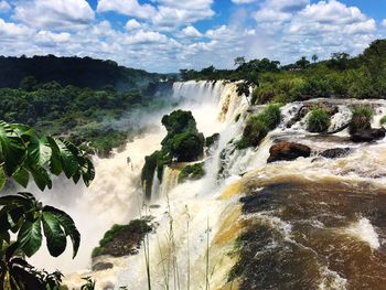 Scenic view of waterfall against sky