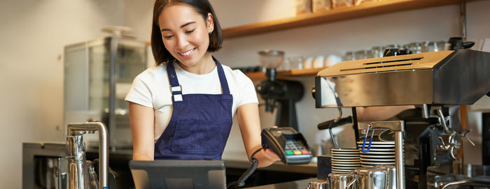 Portrait of young woman standing in cafe