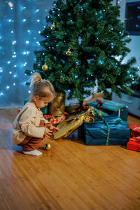 Side view of boy playing with christmas tree