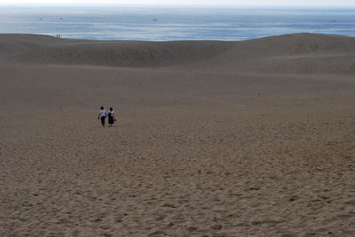 People on beach against sky