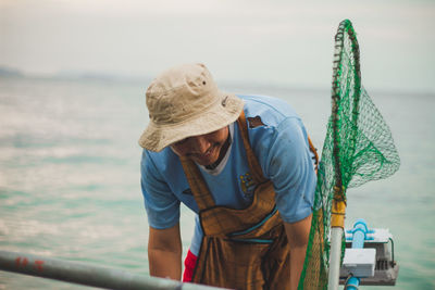 Man with umbrella against sea