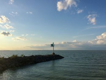 Lighthouse by sea against sky