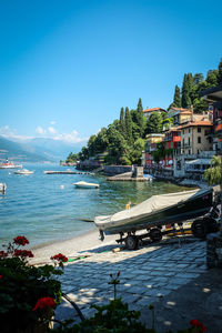 Scenic view of sea by buildings against blue sky