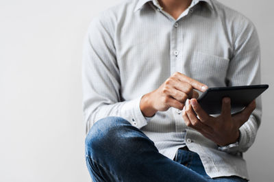 Midsection of man using mobile phone