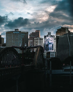 Buildings in city against cloudy sky