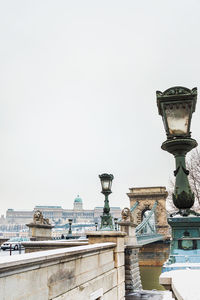 Street light by building against sky