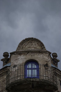 Low angle view of old building against cloudy sky