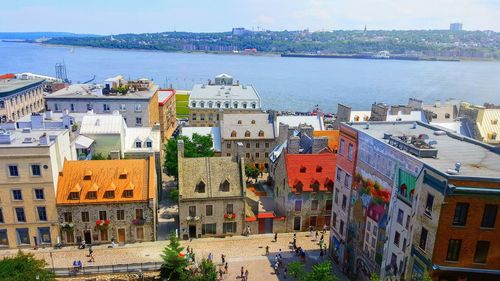 High angle view of buildings by sea against sky