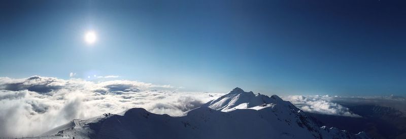 Low angle view of snowcapped mountains against clear blue sky
