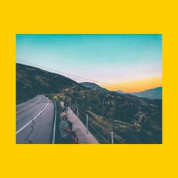 Road by mountain against sky