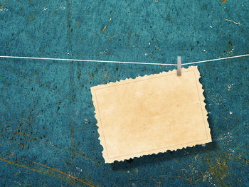 Close-up of paper hanging against weathered wall