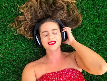 Portrait of young woman lying down on grass