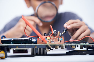 Young schoolboy learning electronic circuit board. detail focus on board component