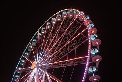 Low angle view of illuminated ferris wheel against sky at night