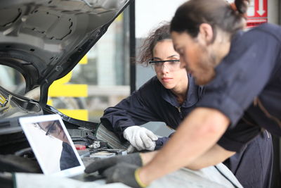 Mechanics repairing car engine