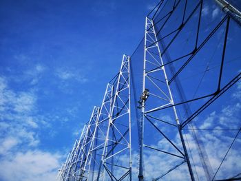 Low angle view of ferris wheel against blue sky