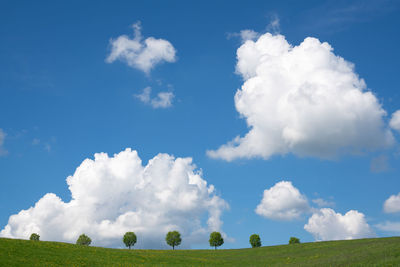 Panoramic landscape of meadow with clouds and blue sky at springtime, bergisches land, germany