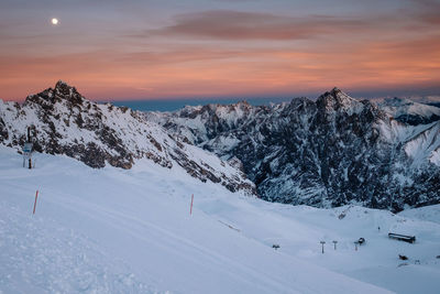 Scenic view of snow covered mountains against sky during sunset