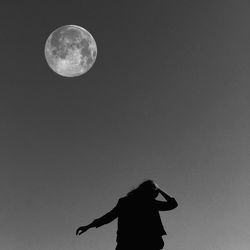 Low angle view of woman against the moon