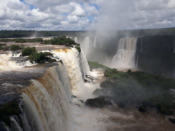 Scenic view of waterfall against sky