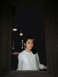 Thoughtful girl standing at window