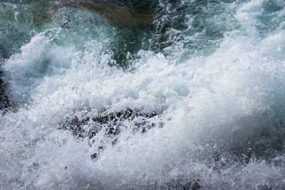 High angle view of waves splashing on rocks